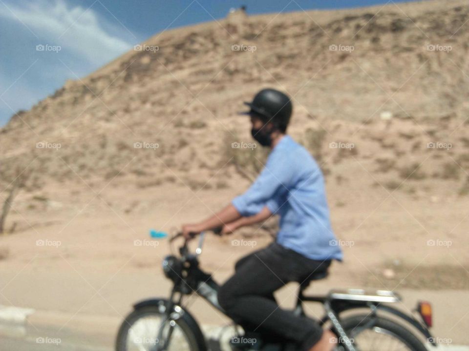 An adult man on motocycle.