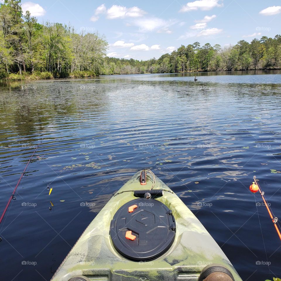 Kayak bass fishing on the blue lake.