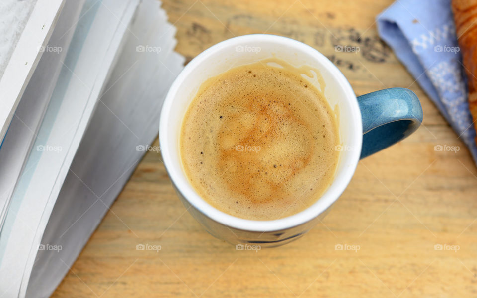 coffee cup on a wooden background with coffee bean stamp and news paper