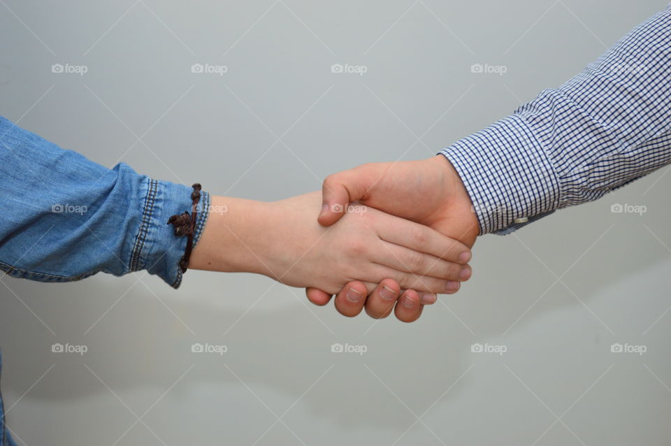 Close-up of holding hands against grey background