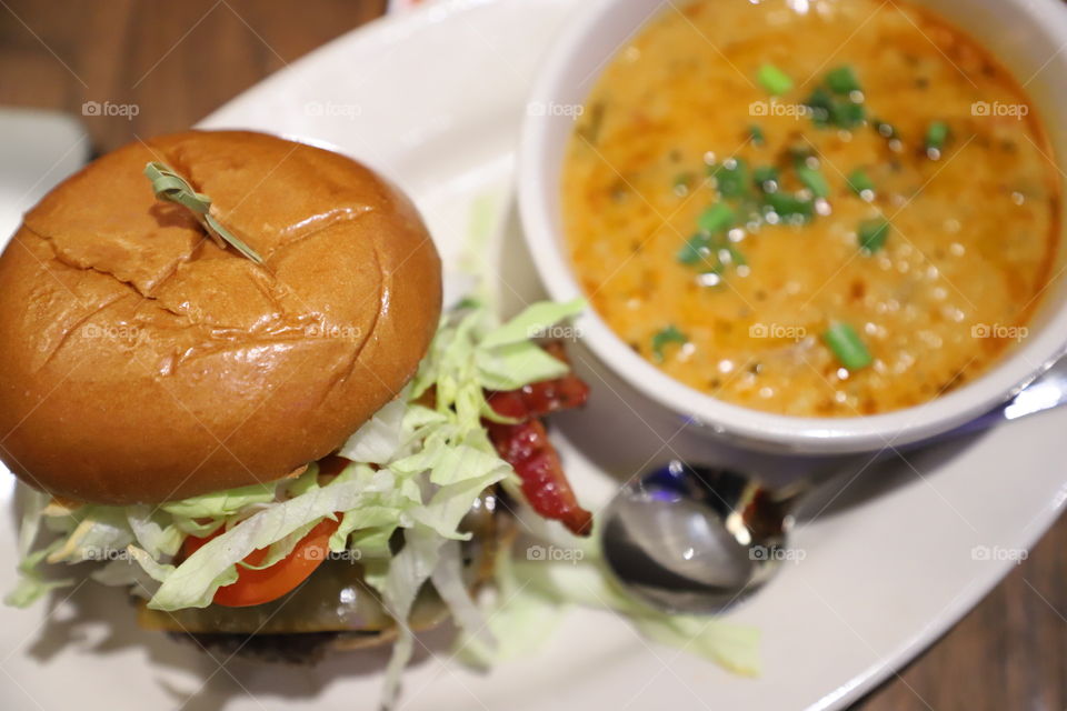 Burger and soup on a big white plate 