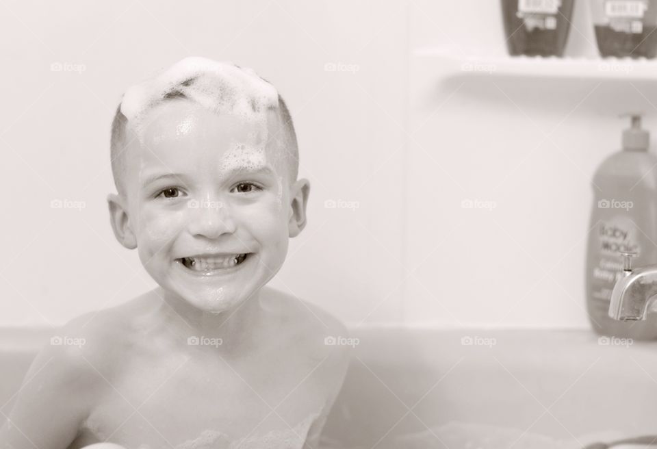 Close-up of a boy bathing in tub