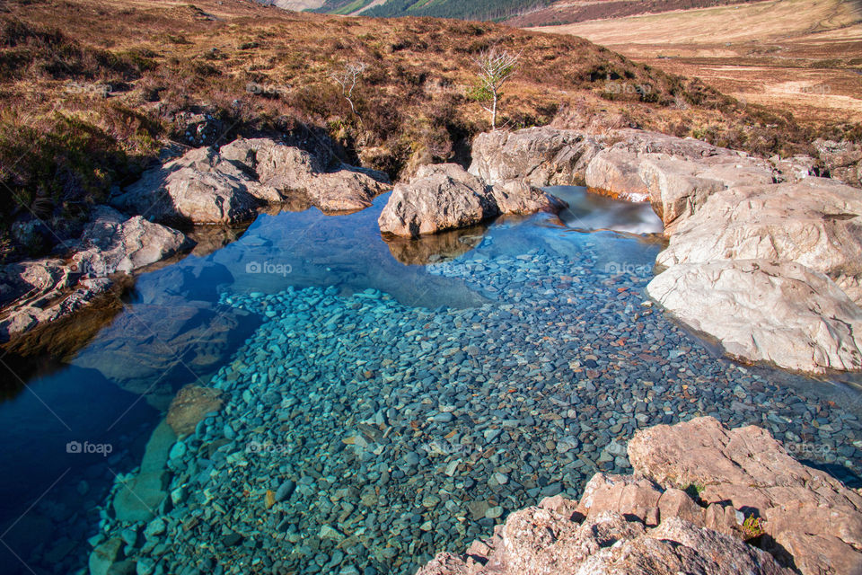 The rocky coastline and stones under the water