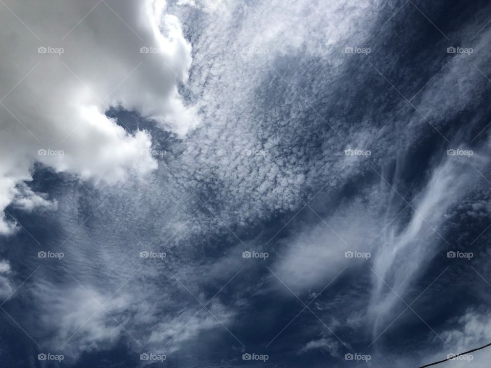 Looking up to the sky on a not so cloud day. Different types of clouds together, but the sky is still blue...