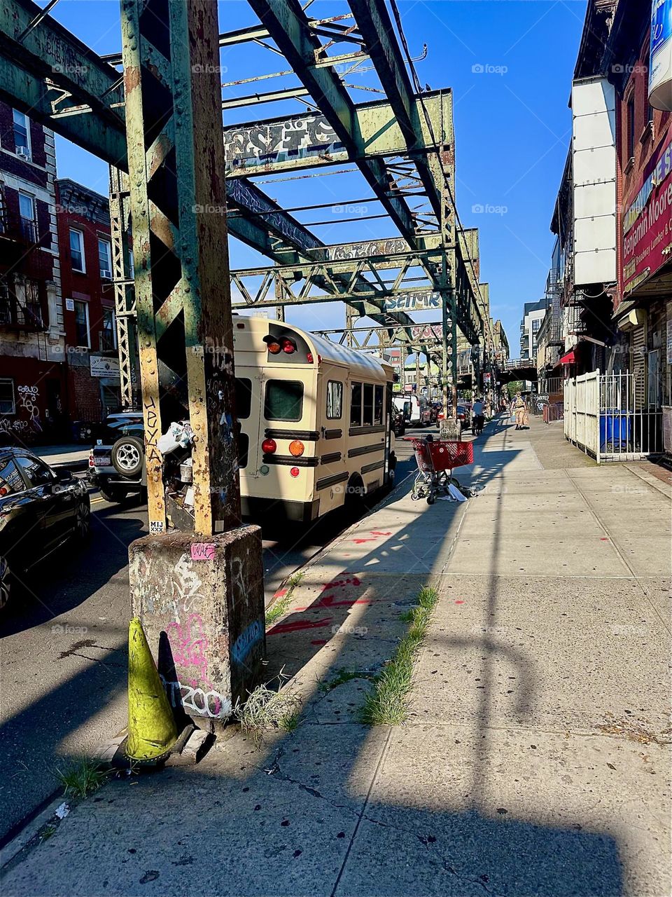 Dramatic elongated shadows extend towards the distance cast by the “Myrtle Ave”, “Bushwick”, Bklyn overpass in the late afternoon sun. 2024. Hypnotic Productions