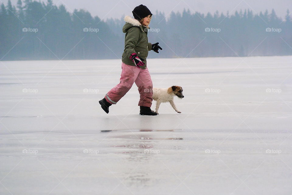 Girl and a dog playing on the ice