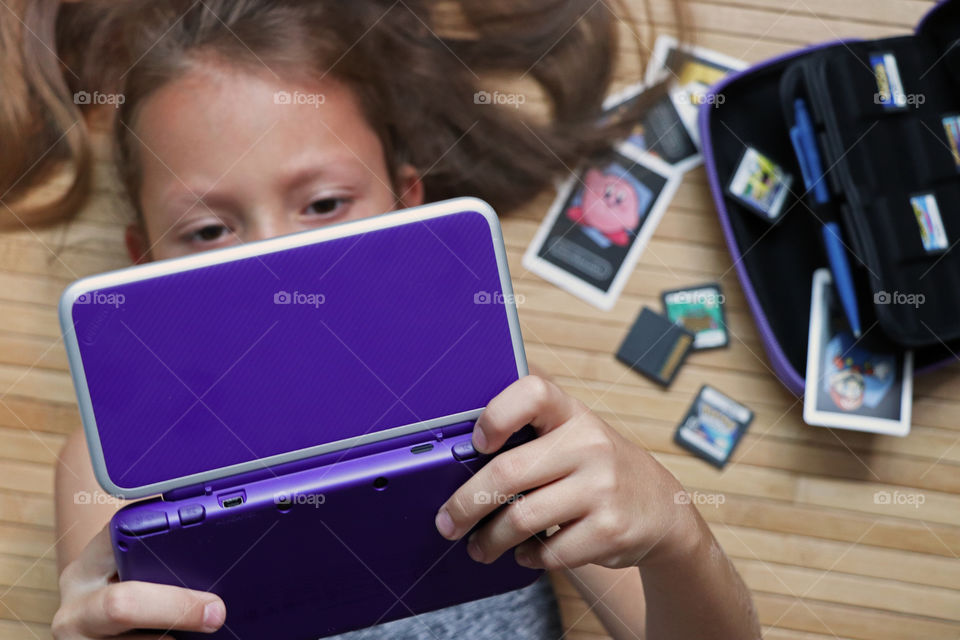 Little girl playing video game on a Nintendo DS