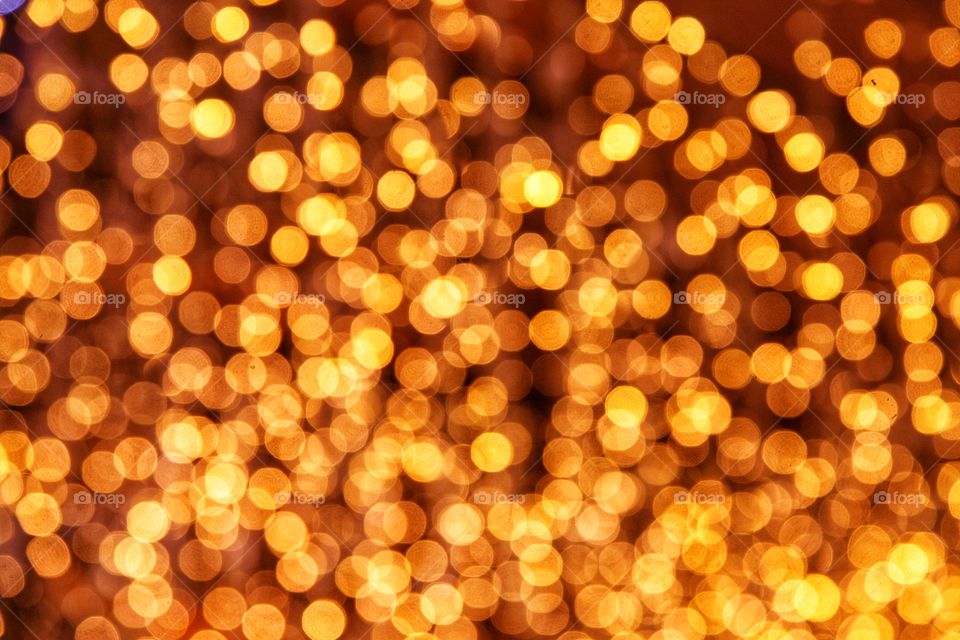 Golden​ spherical​ lights​ glittering​ the​ background​