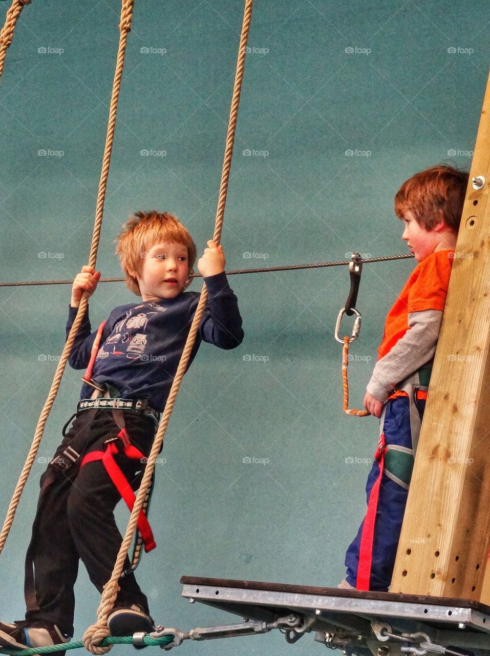 Looking Up To Big Brother. Brothers Crossing A Rope Bridge
