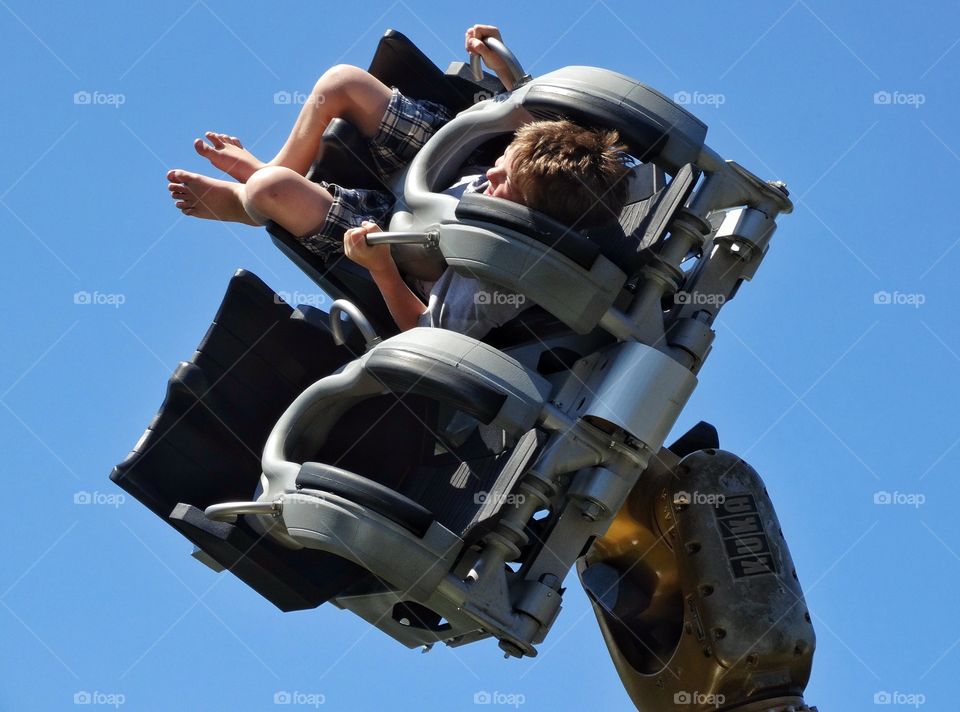 Boy Riding Rollercoaster. Young Boy On A Thrill Ride At Amusement Park
