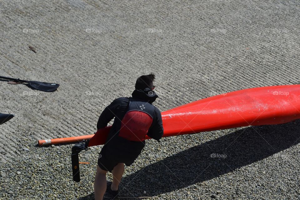 Pulling the kayak up the boat ramp. Man pulling kayak