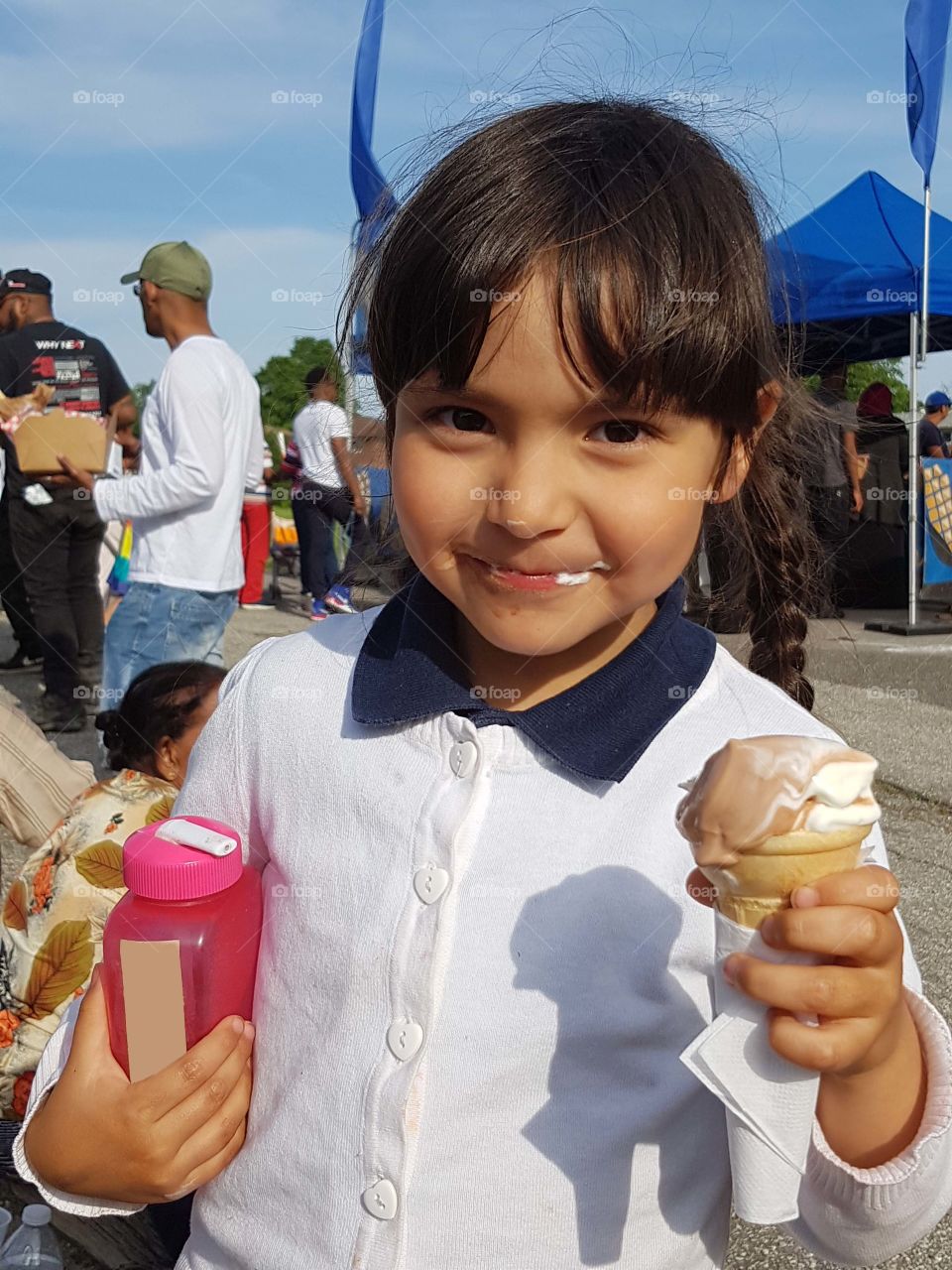 Girl is eating ice cream on a school fun fair