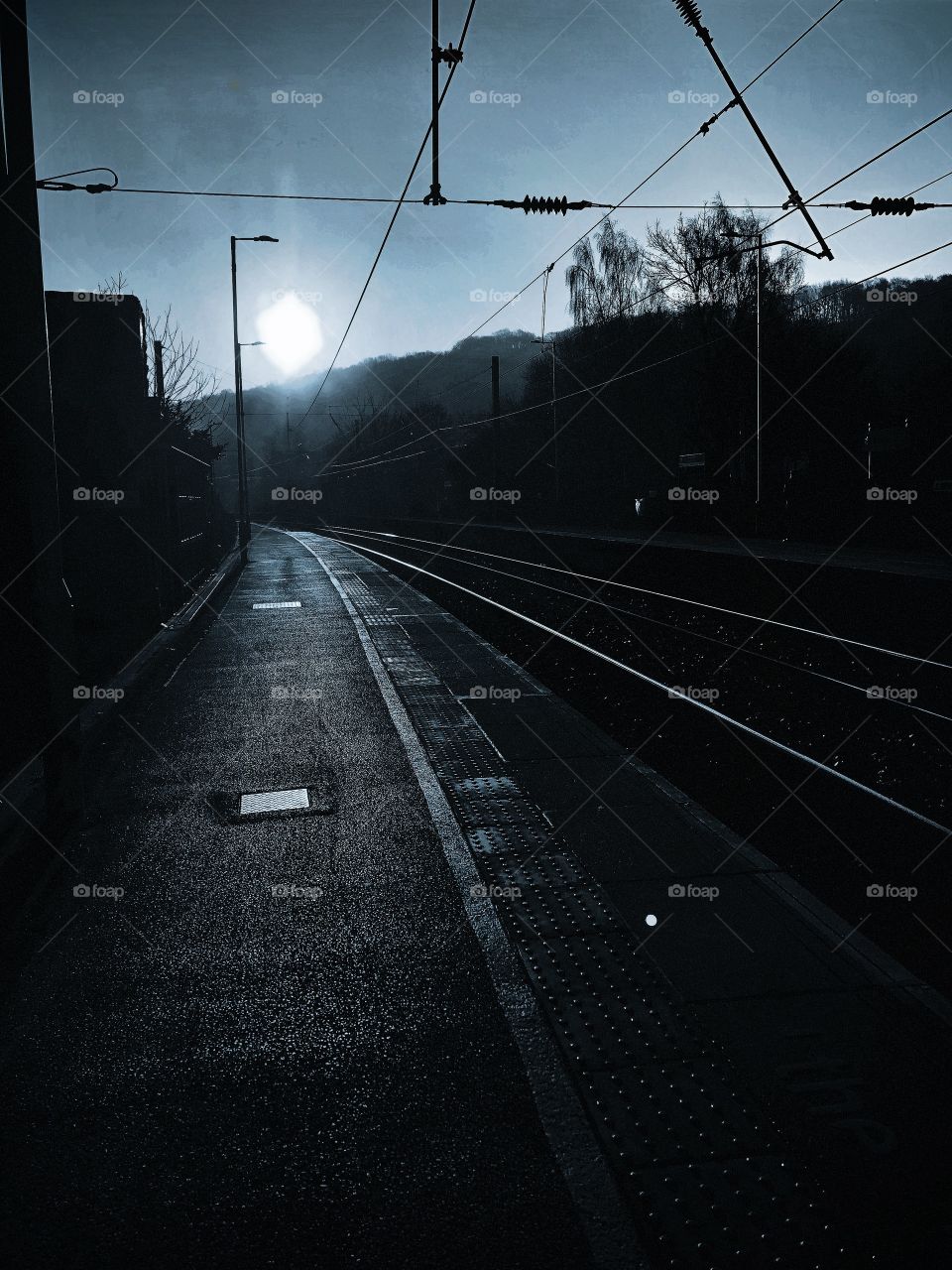 Early morning looking down the track waiting for a train. The sun is just rising