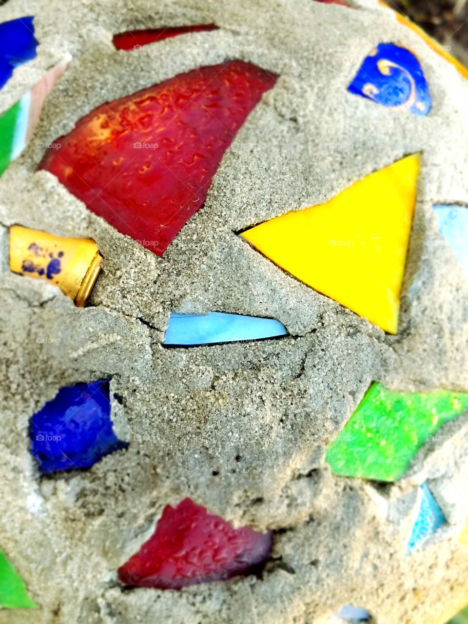 Bright colors of broken glass in cement around our flowers