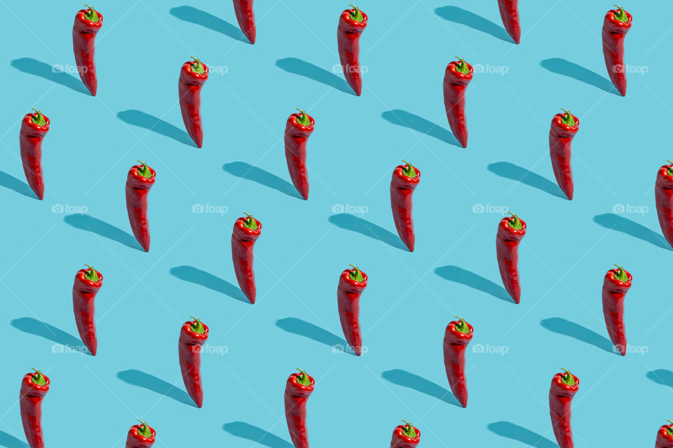 Red chilli pepper on blue background pattern
