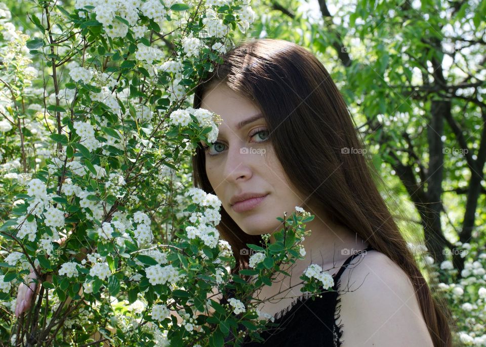 Portrait of a Beautiful Young Girl on Background of Flowers