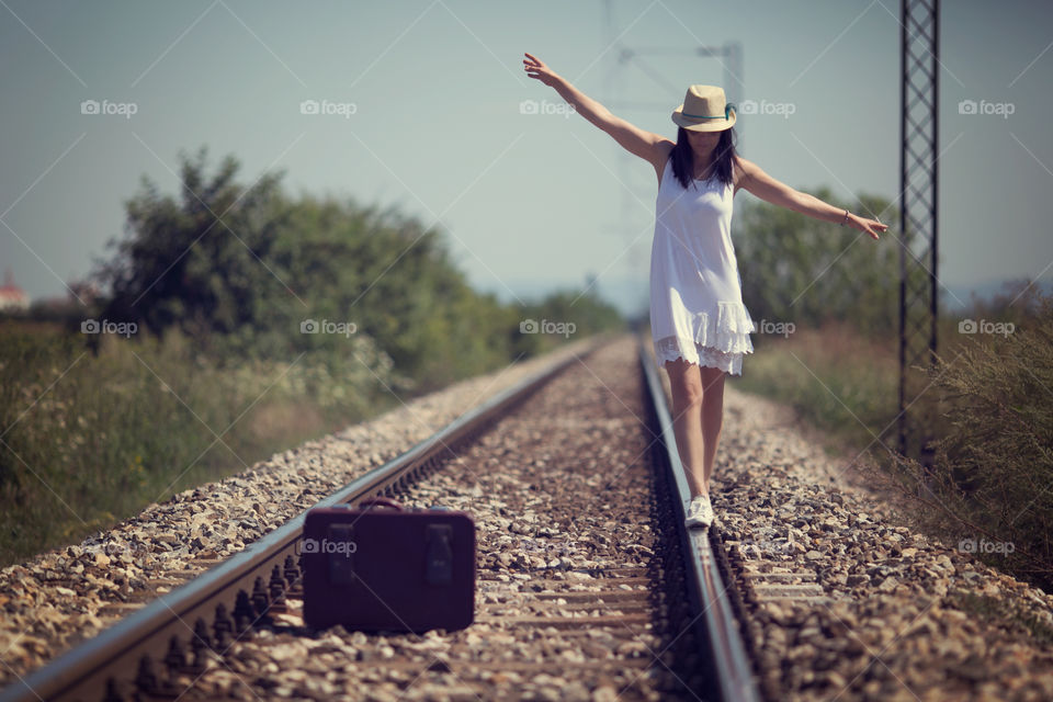 View of elegant woman walking on railway track