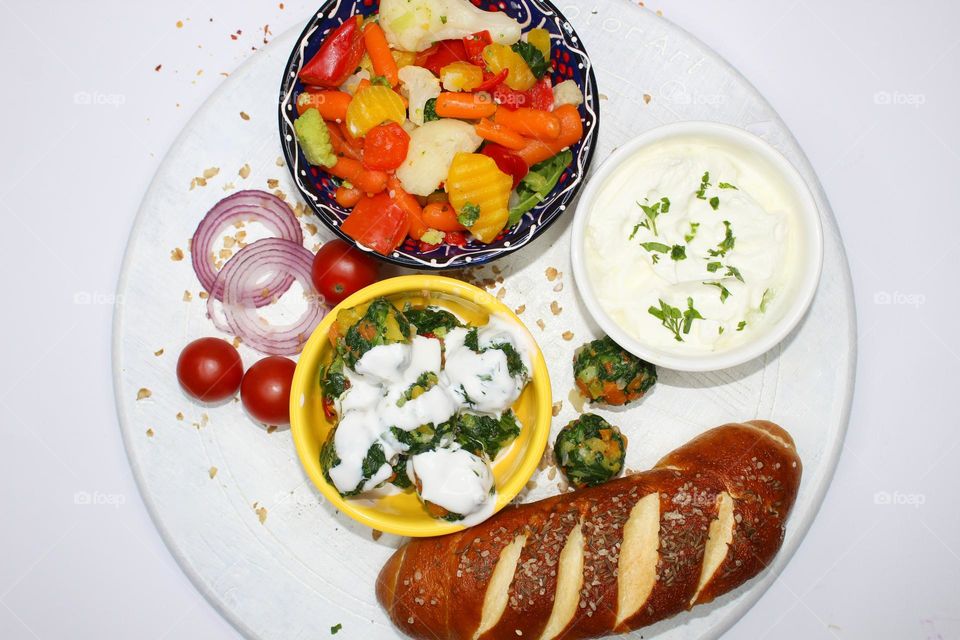 Mixed vegetables( carrots, cauliflower, broccoli, spinach, onion, cherry) ,yogurt and pastries on a wooden background.  Top view of food