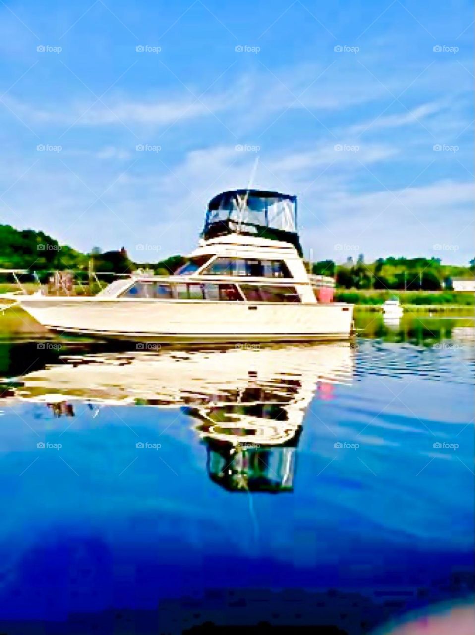 A motorboat with a stacked fly bridge driving through the smooth blue waters of the East River on a bright sunny afternoon in the summer of 2020. Hypnotic Productions