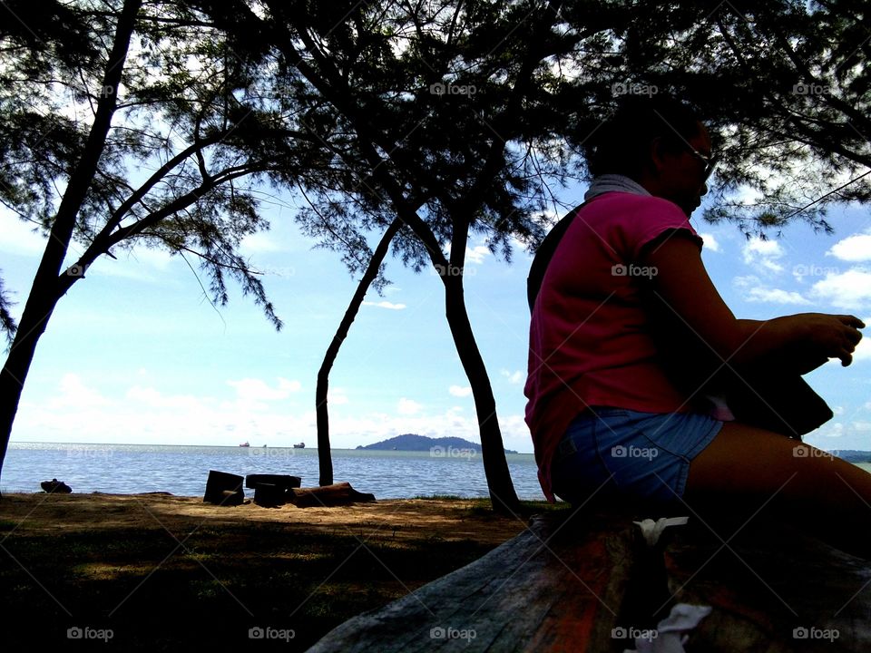 A woman playing with hand phone at the beach