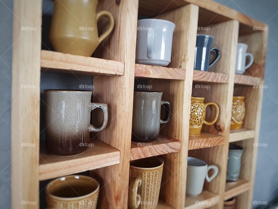 vintage mugs and pottery in wooden shelf