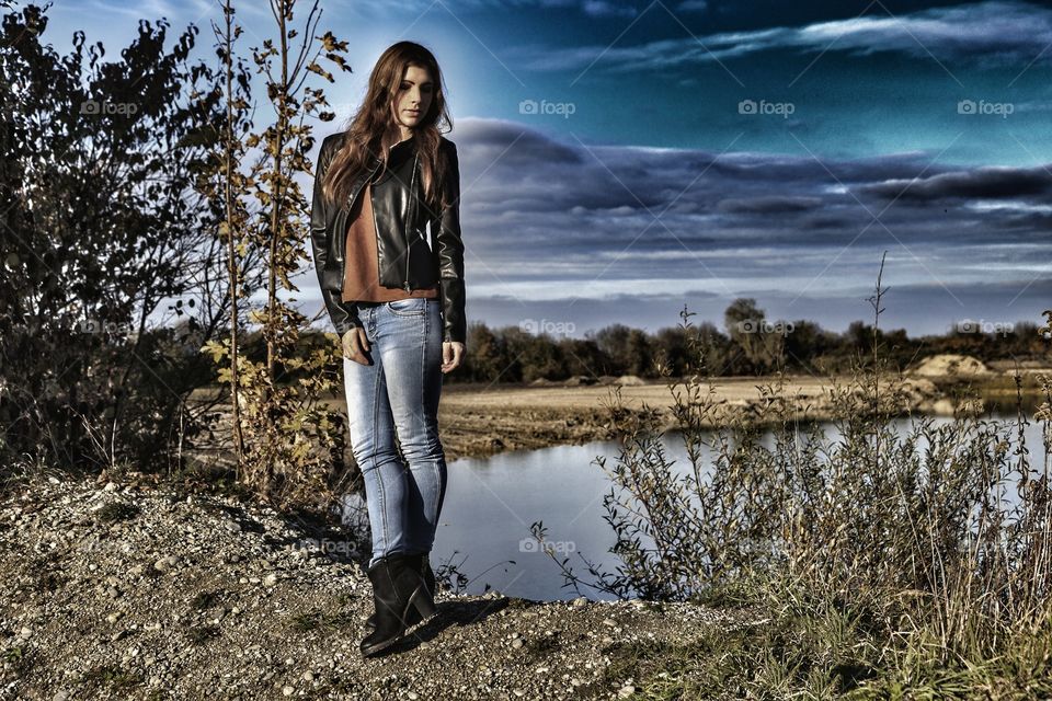 Stylish woman posing in front of lake