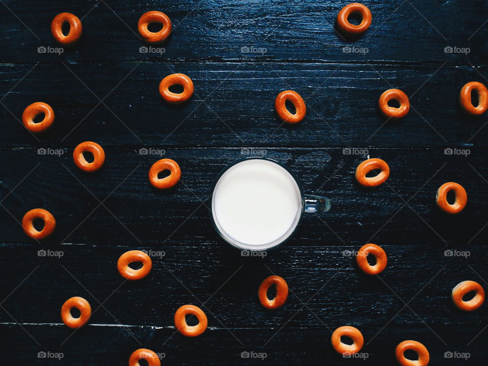 cup of homemade milk and bagels on a black background