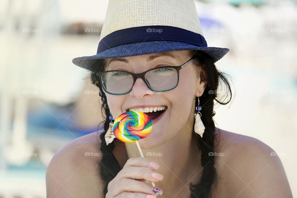 Smiling woman holds colorful lollipop