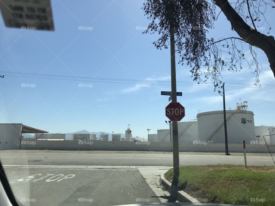 Stop sign in front of chemical tanks