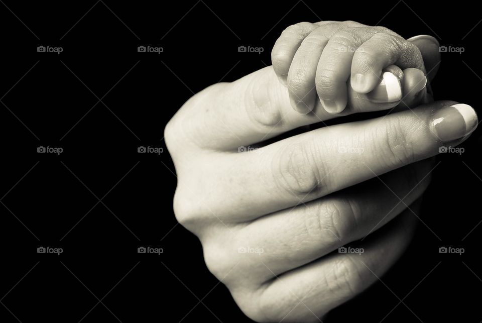 Baby's hand holding mother's finger
