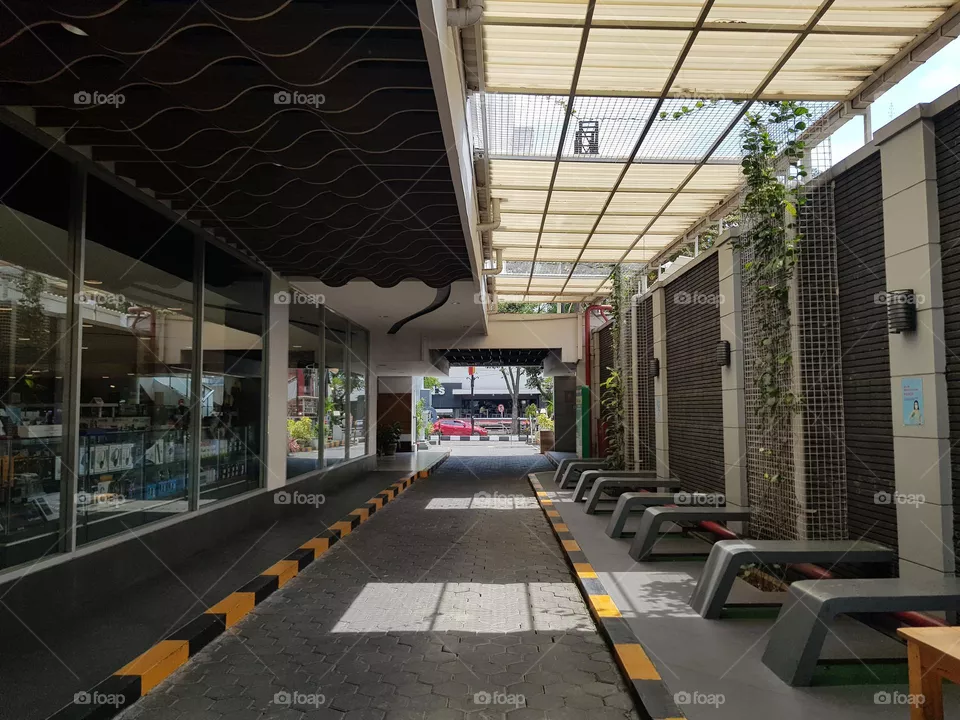 Alleys - corridor, small road between two shopping building, transparent coverd corridors, benhces on side of the alley, block floors, plant - flowers decorating corridor walls