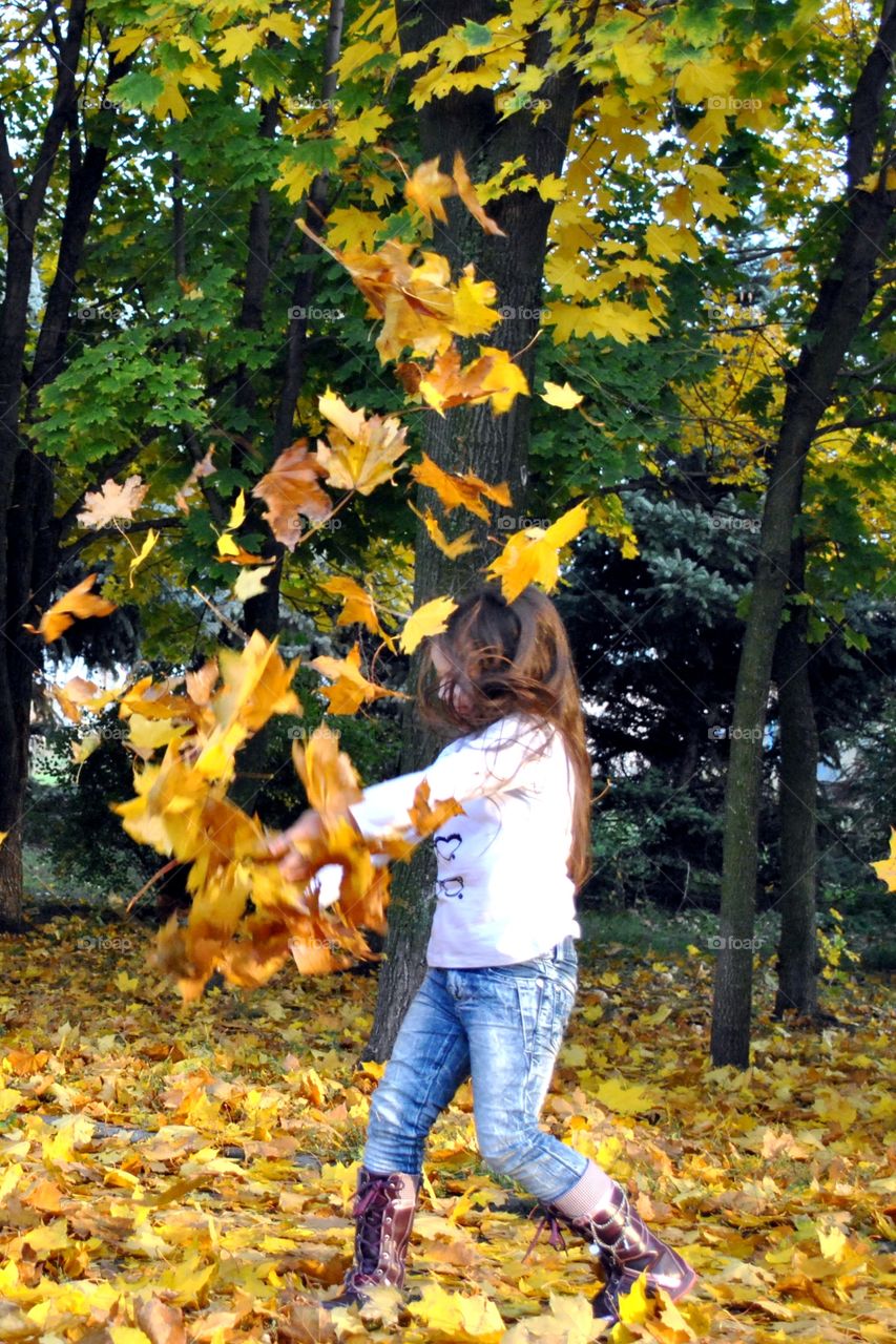 girl throwing leaves