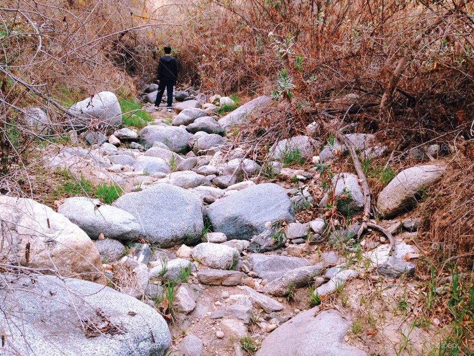 Man hiking in dry riverbed