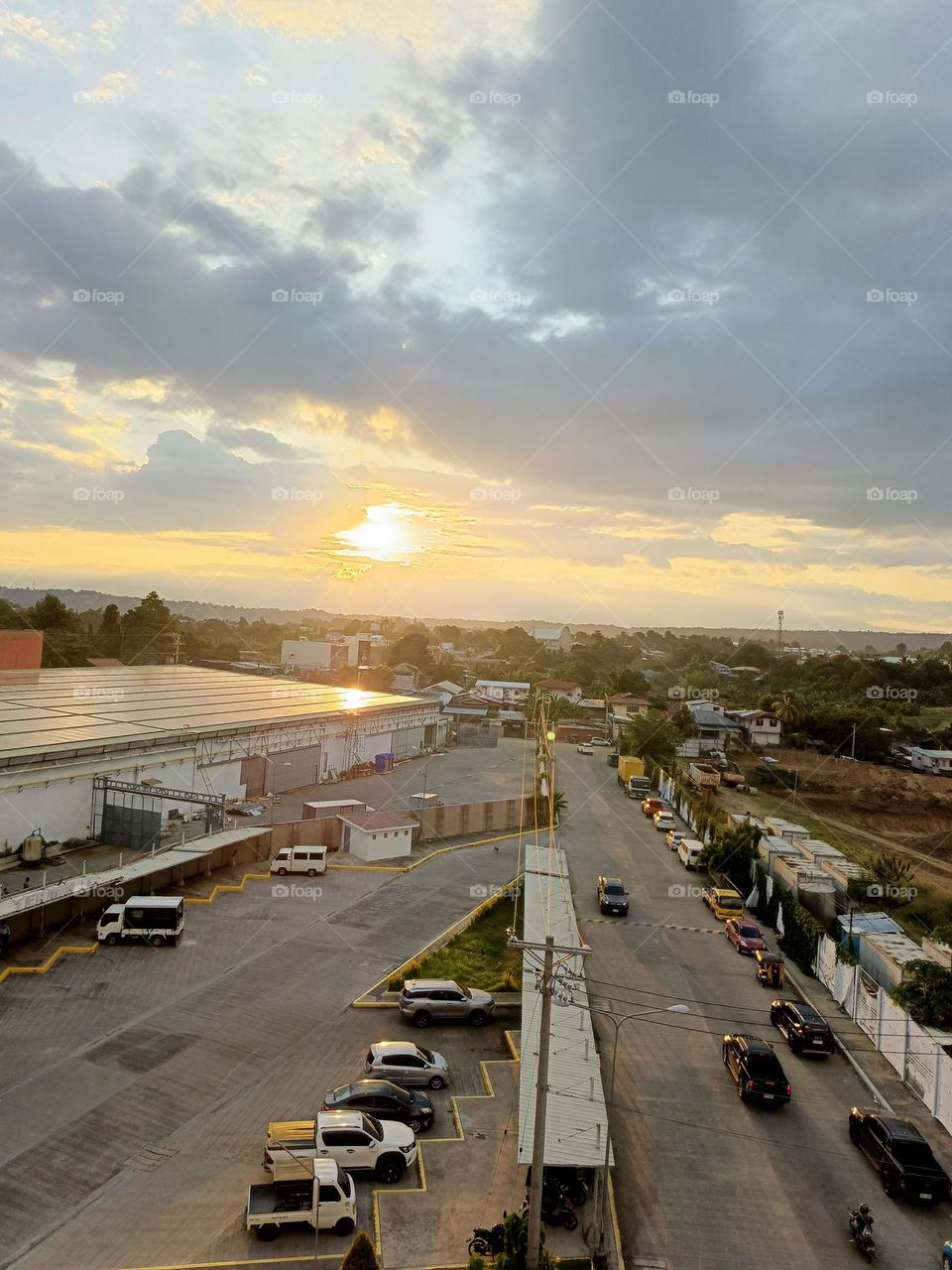 "A golden dawn breaks over quiet rooftops, turning the ordinary into something beautifully alive."