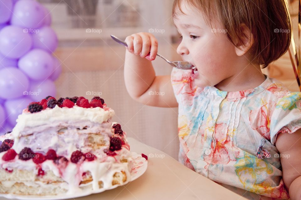 Cute little girl eating the cake