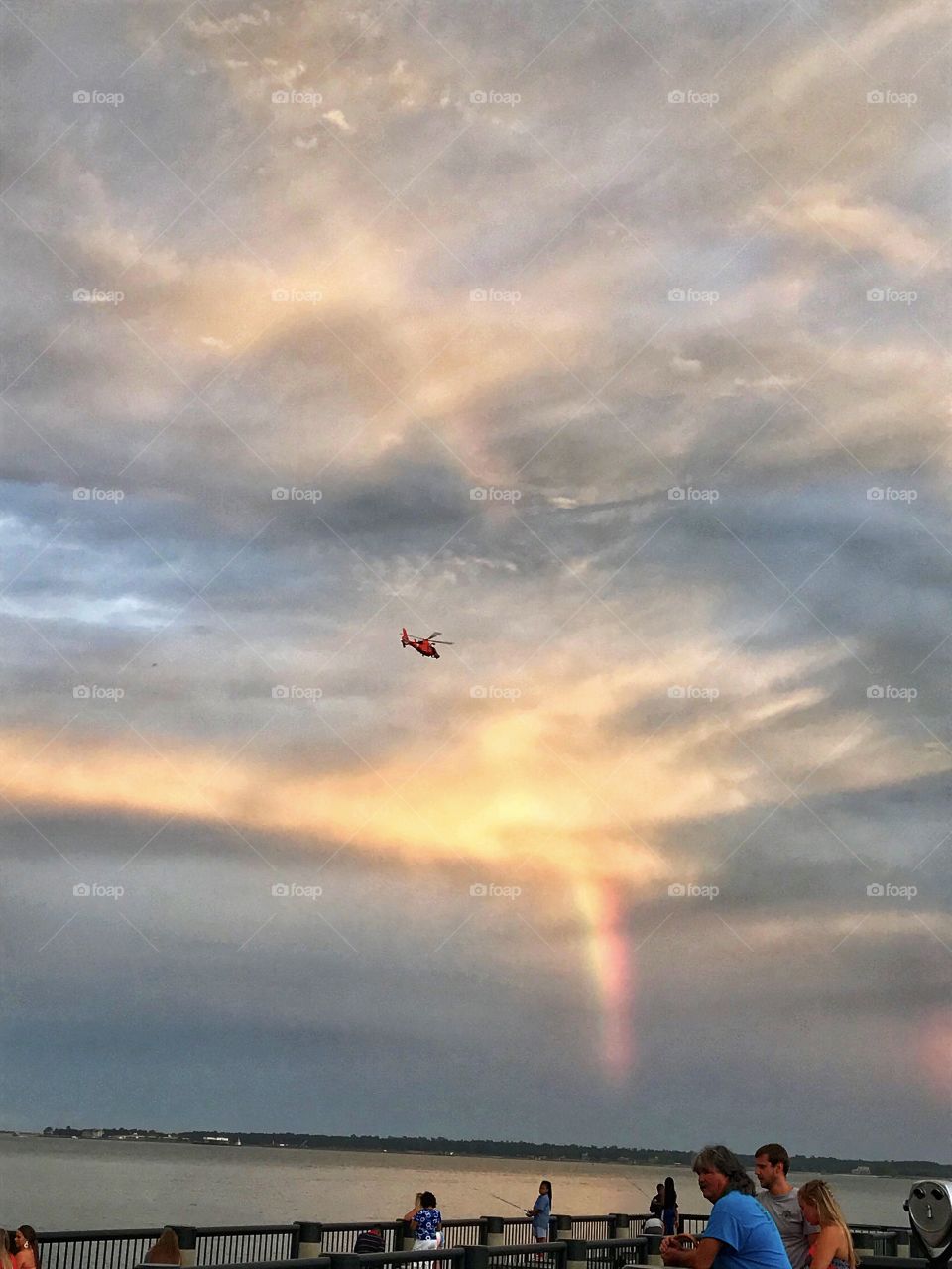 Helicopter among clouds and a rainbow