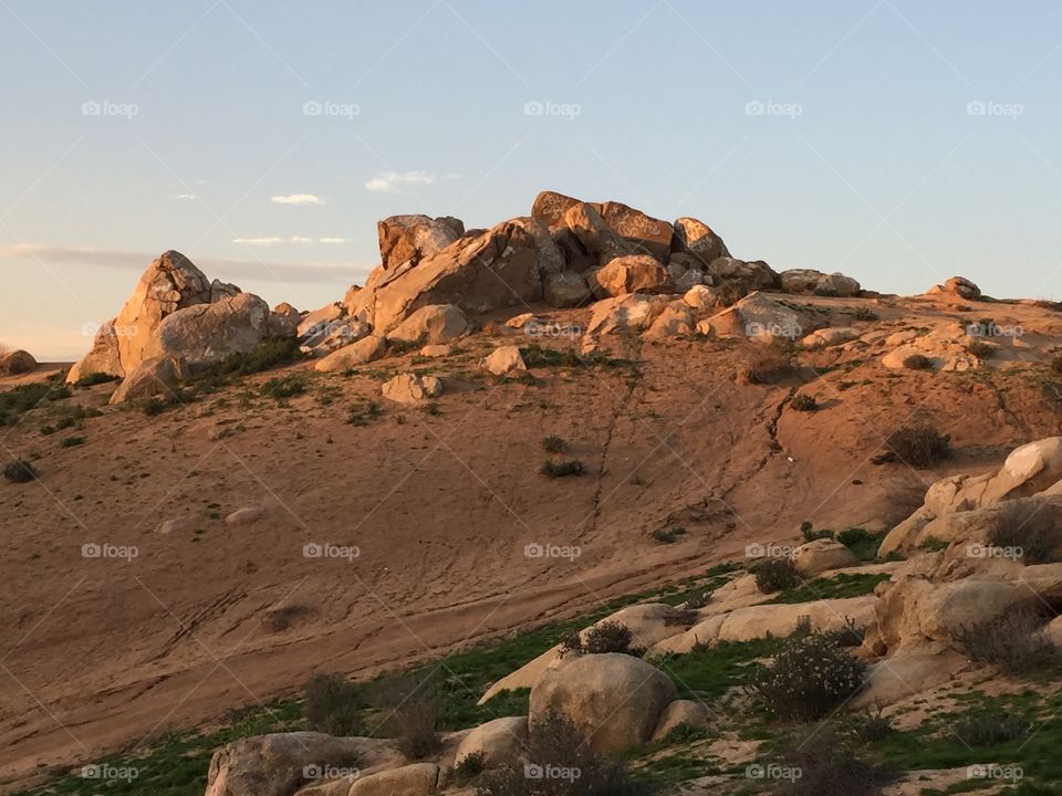 Sun setting on boulders topping a hill