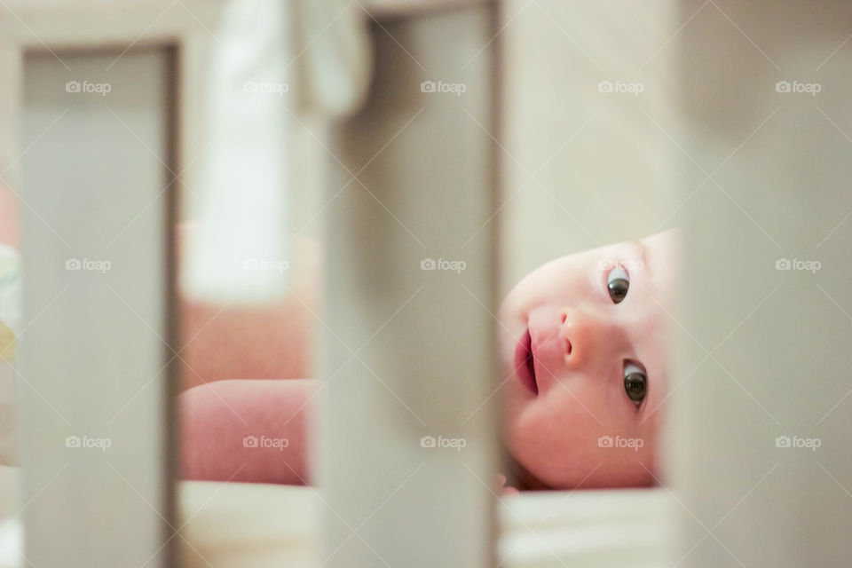 Baby smiling through crib