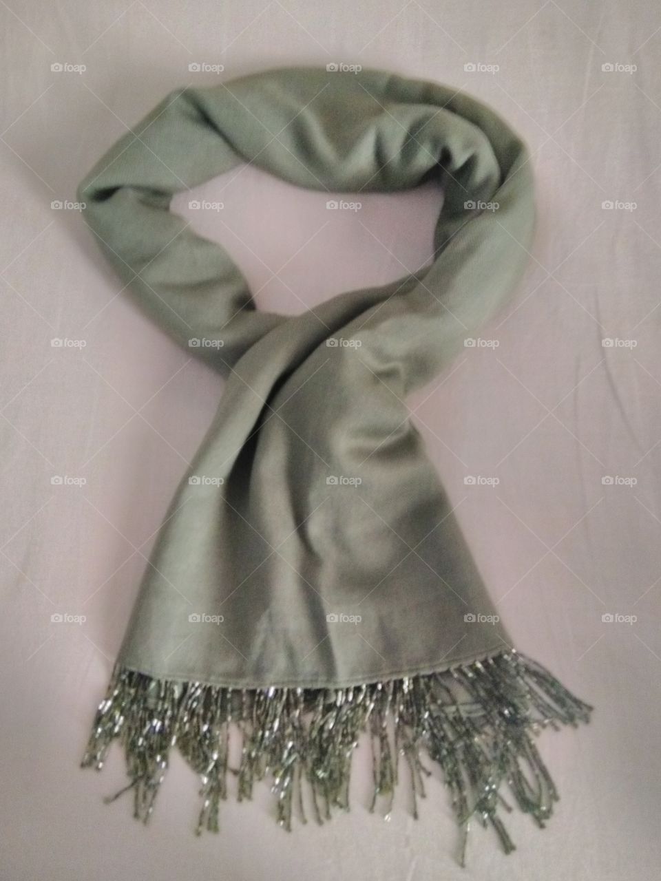 This photo shows a beautiful jungle green scarf with a beaded finishing. It can be worn with official or casual attires.