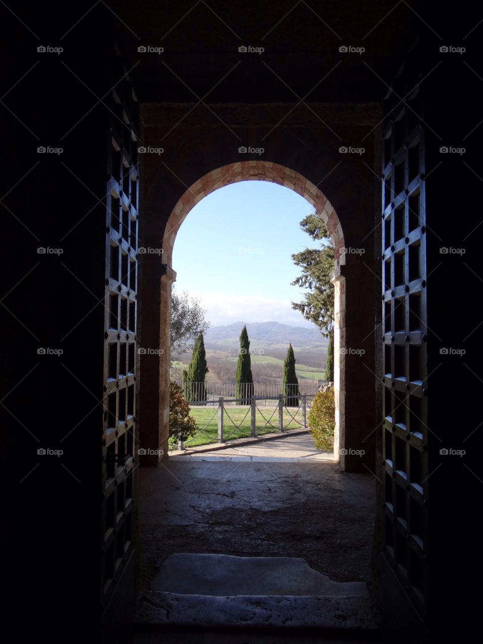 Beautiful landscape in Tuscany, seen through a church door

