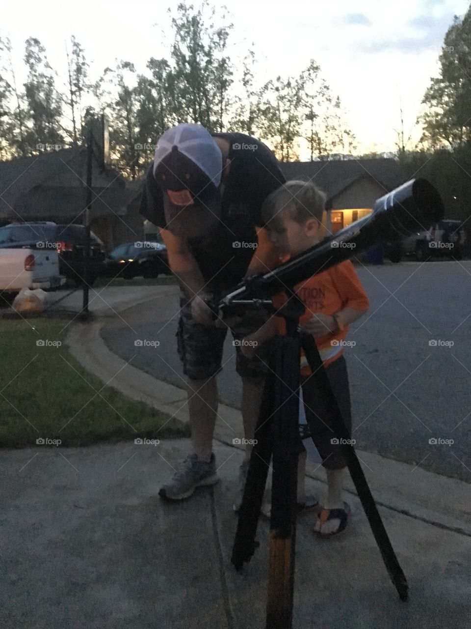 Man and his son standing near road with binocular