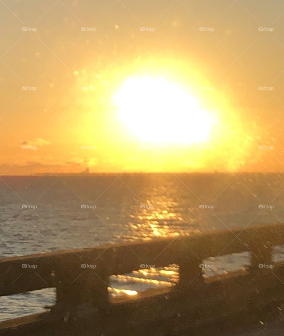 Sun coming up after storm Zeta on Lake Ponchatrain in New Orleans, Louisiana giving off a glorious glow on the water.