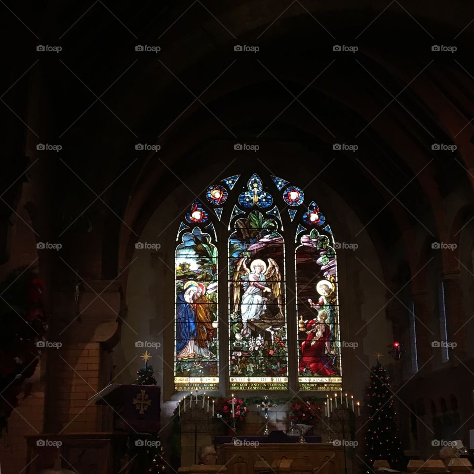 Stained glass window in a picturesque church decorated for Christmas. Church of the Angels, Pasadena, California.