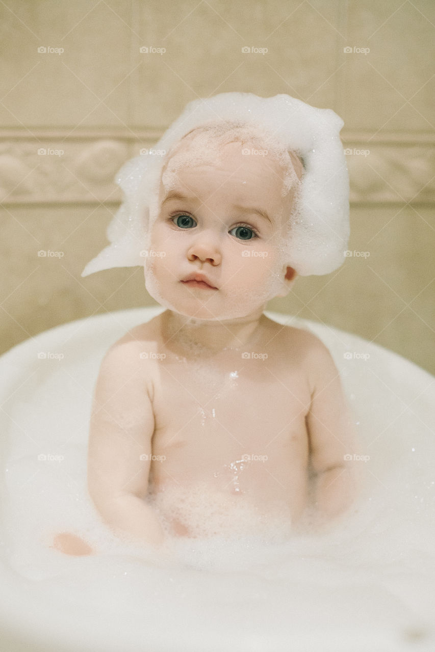 Cute baby-girl with foam on head