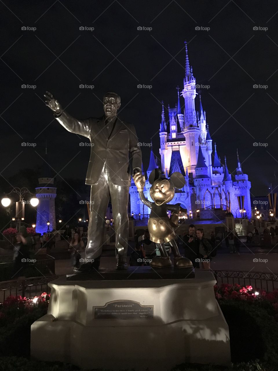 Statue of Walt Disney & Mickey in front of castle