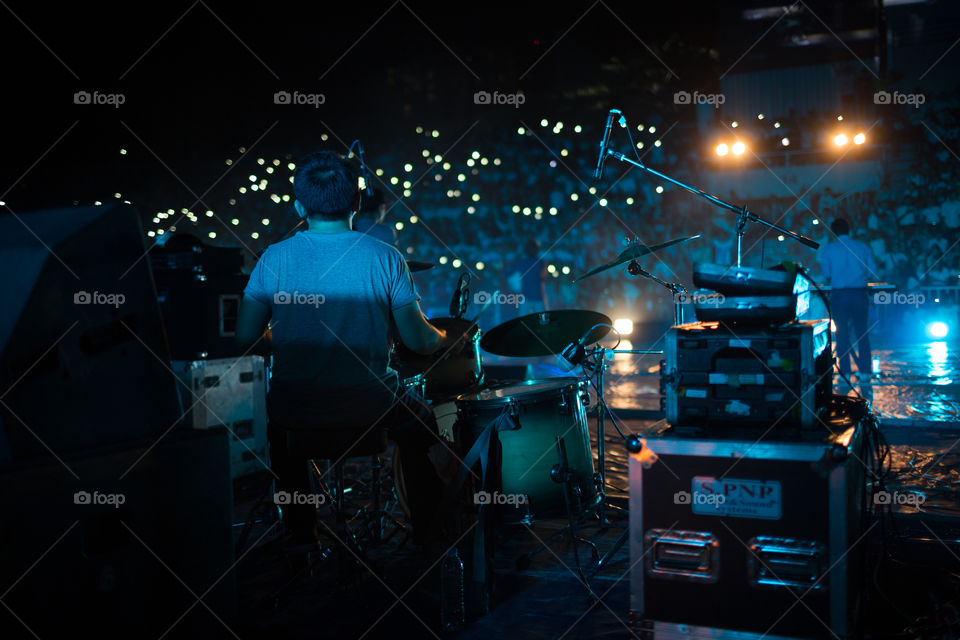 Concert in the stadium at night from view from the drum behind the band