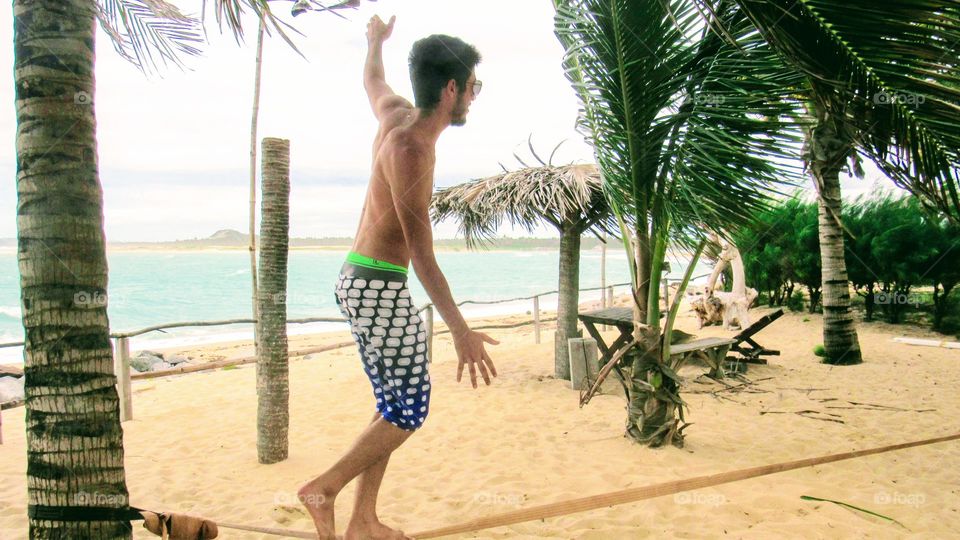 Boy practicing sky line on the beach