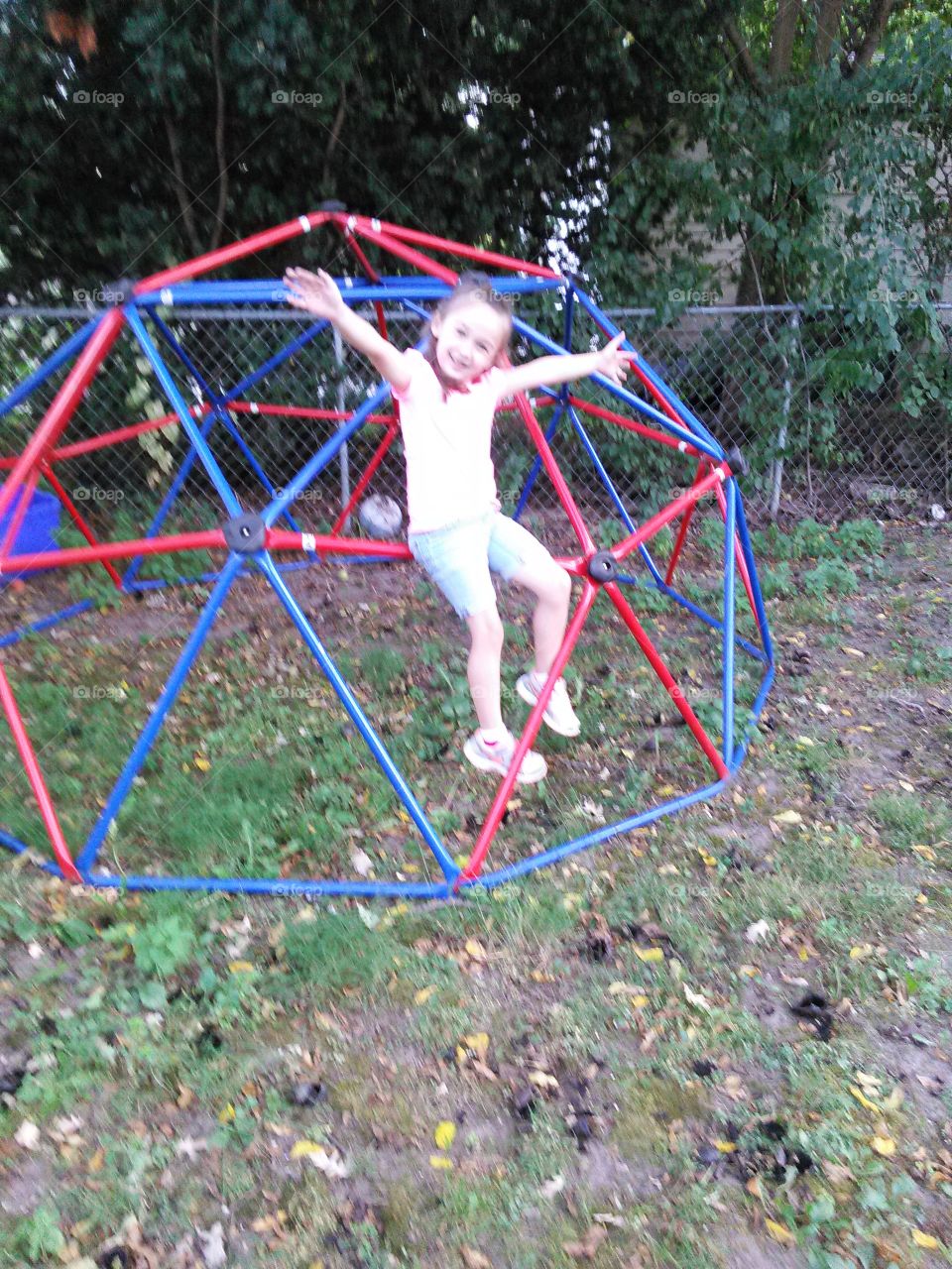 Tada, look ma no hands!. little girl on monkey bars