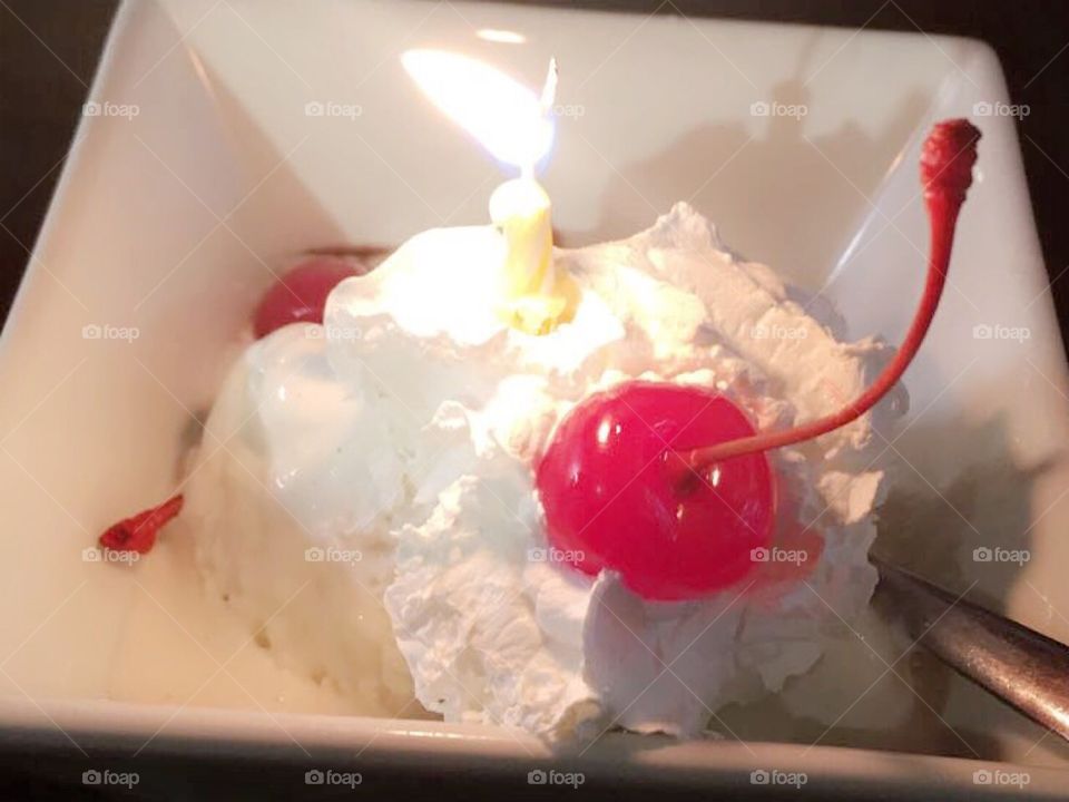 Birthday cake with ice cream and a lit candle