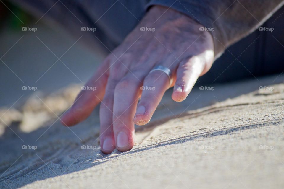 Mans hand in the sand